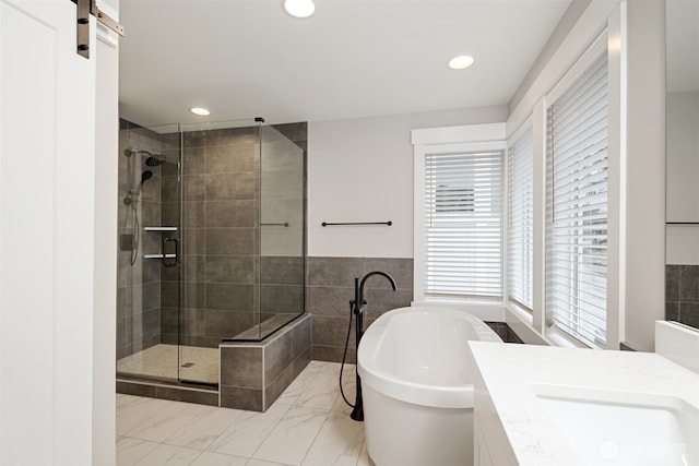 bathroom with recessed lighting, vanity, a freestanding bath, marble finish floor, and a stall shower