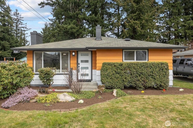 view of front of house featuring a front lawn and a chimney