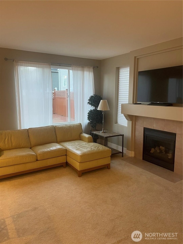 carpeted living room featuring a fireplace and baseboards