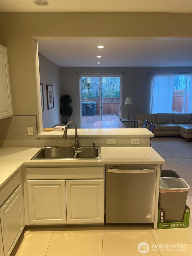 kitchen with white cabinets, a sink, and dishwasher