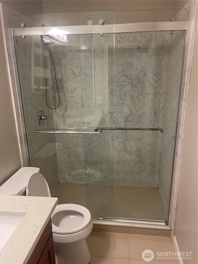 bathroom featuring a shower stall, vanity, and toilet