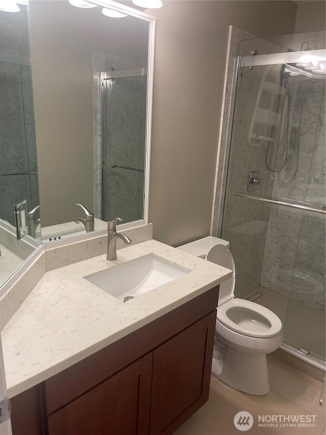 full bath with a stall shower, vanity, toilet, and tile patterned floors