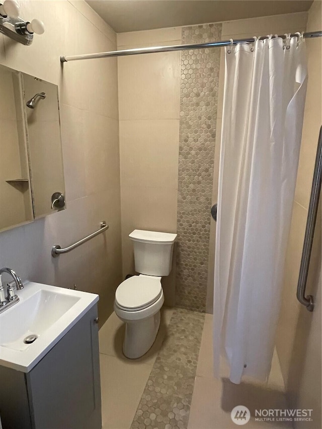 full bath featuring a shower with curtain, tile patterned flooring, vanity, and toilet