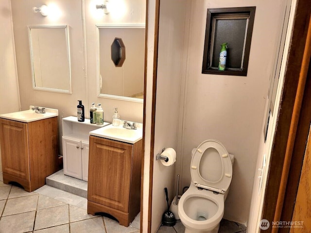 full bath with two vanities, a sink, toilet, and tile patterned floors