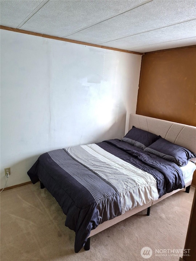 carpeted bedroom with a textured ceiling and crown molding