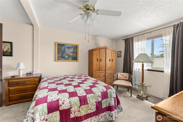 carpeted bedroom with ceiling fan and a textured ceiling