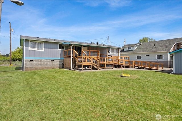 rear view of house featuring a lawn, crawl space, fence, and a deck