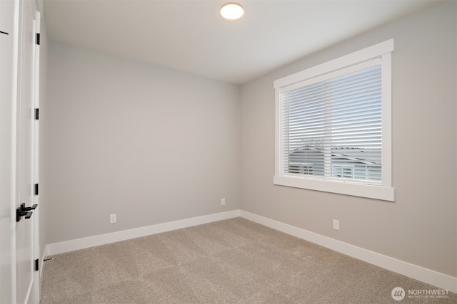 unfurnished room with light carpet and baseboards