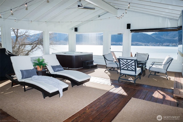 interior space with lofted ceiling with beams and a ceiling fan