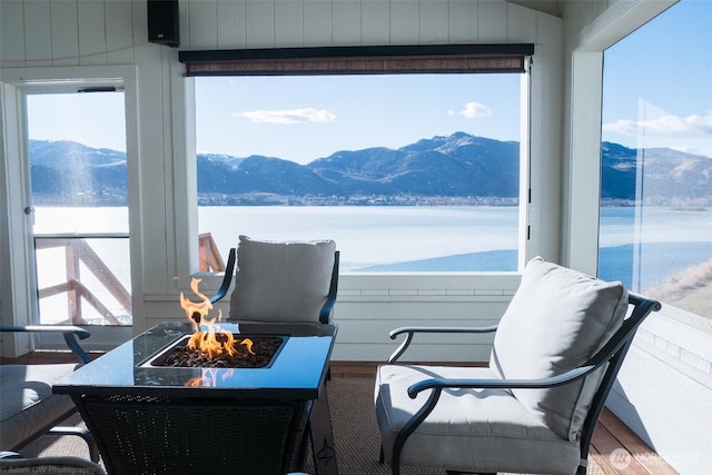 view of patio featuring a fire pit, a water and mountain view, and a balcony