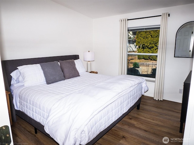 bedroom with baseboards and wood finished floors