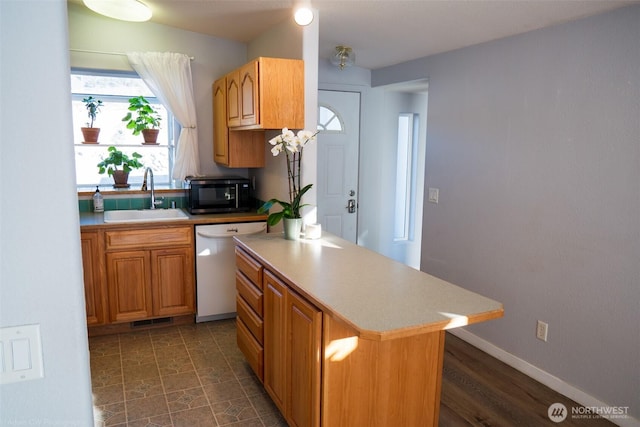 kitchen with dishwasher, a kitchen island, light countertops, black microwave, and a sink