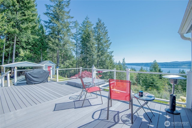 wooden terrace featuring an outdoor structure and a storage unit