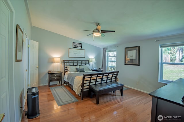 bedroom with light wood-style floors, multiple windows, and baseboards