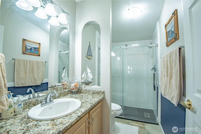 full bath with toilet, a shower stall, and vanity