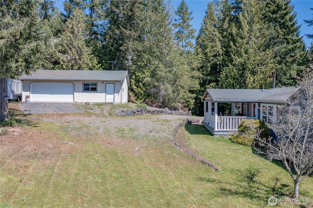 view of yard featuring an attached garage and covered porch