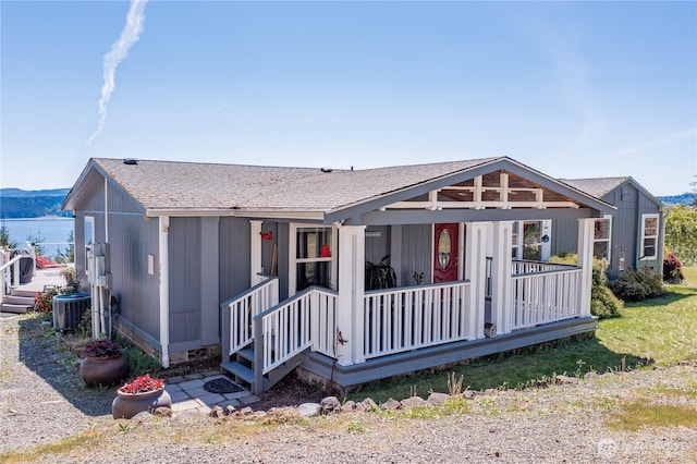 view of front of home featuring covered porch, roof with shingles, and central air condition unit