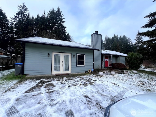 view of front of house with a chimney and french doors