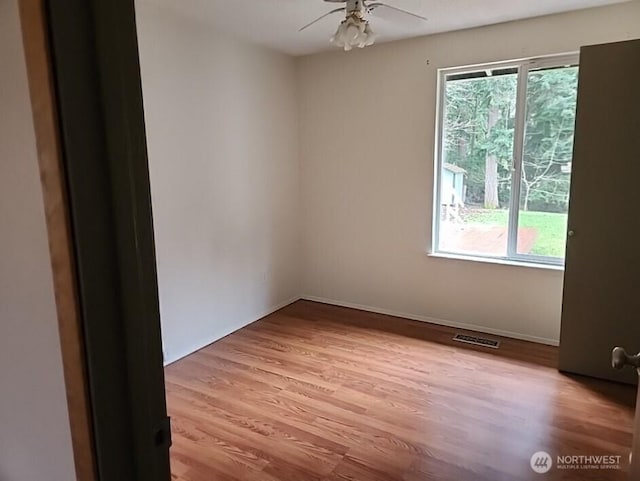 unfurnished room featuring light wood-style floors, visible vents, ceiling fan, and baseboards