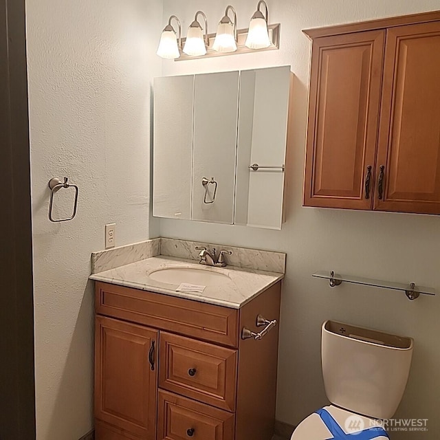 half bath featuring toilet and vanity