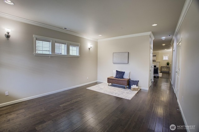 sitting room with visible vents, baseboards, dark wood-type flooring, and crown molding