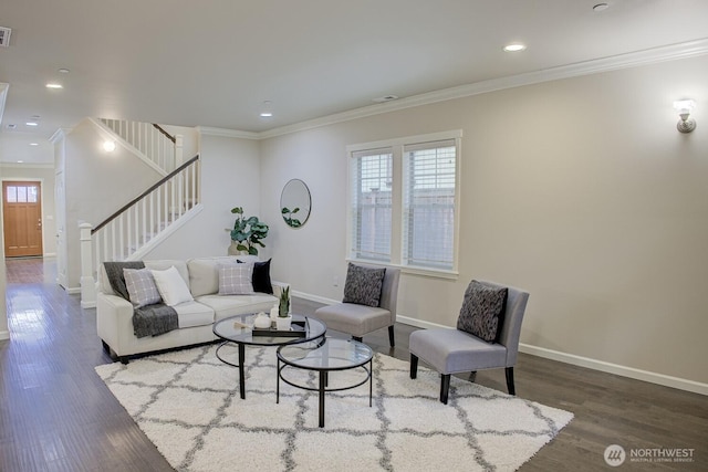 living area with stairway, a healthy amount of sunlight, crown molding, and wood finished floors