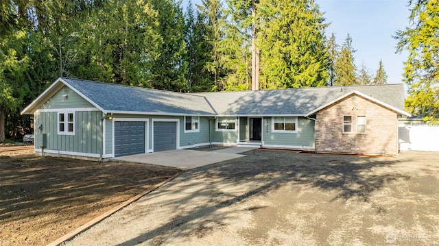 ranch-style home with driveway, board and batten siding, and an attached garage