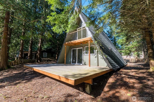 rear view of property featuring a deck and fence