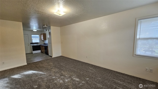 empty room with dark carpet and a textured ceiling