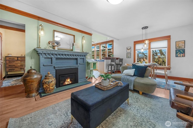 living room featuring a glass covered fireplace, wood finished floors, and a wealth of natural light