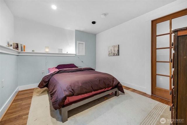 bedroom with recessed lighting, wood finished floors, and baseboards