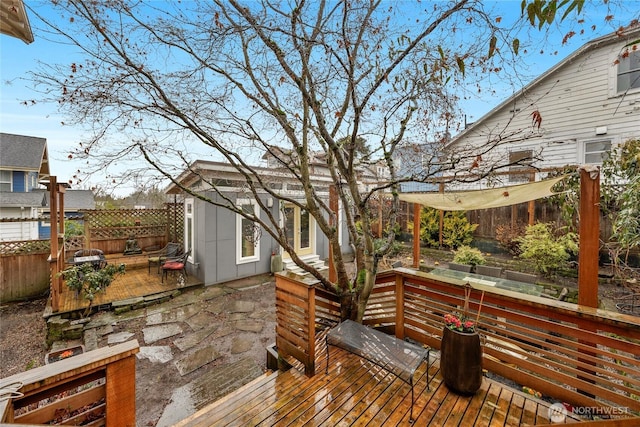 wooden terrace with an outbuilding and fence