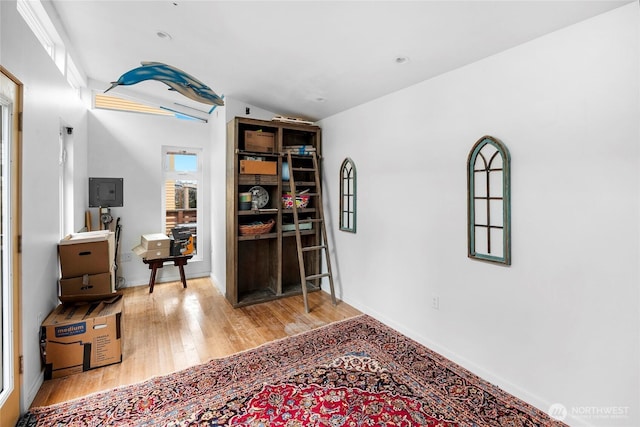 interior space featuring vaulted ceiling, baseboards, and wood finished floors