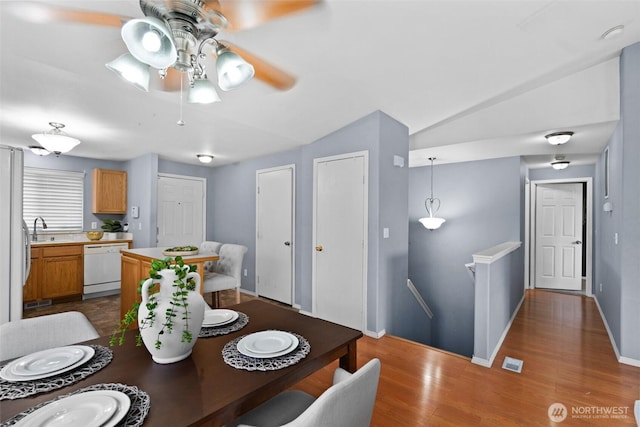 dining space featuring baseboards, a ceiling fan, lofted ceiling, and wood finished floors