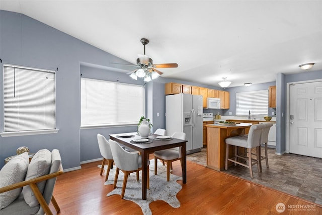 dining room with ceiling fan, lofted ceiling, and wood finished floors