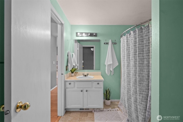 full bath with vanity, a shower with curtain, and baseboards