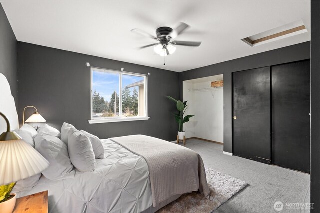 bedroom featuring two closets, baseboards, ceiling fan, carpet, and attic access