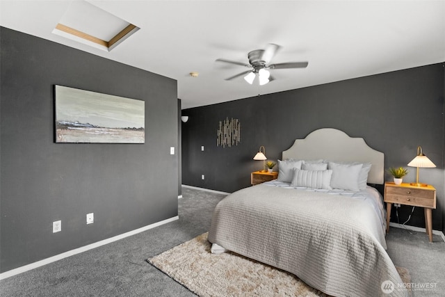 bedroom featuring carpet floors, baseboards, attic access, ceiling fan, and an accent wall