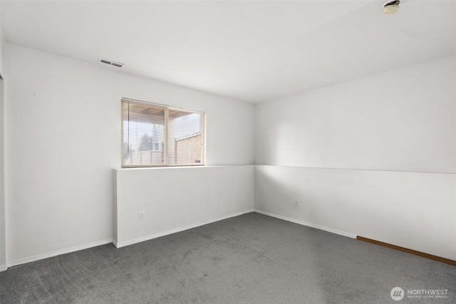 spare room with visible vents, baseboards, and carpet