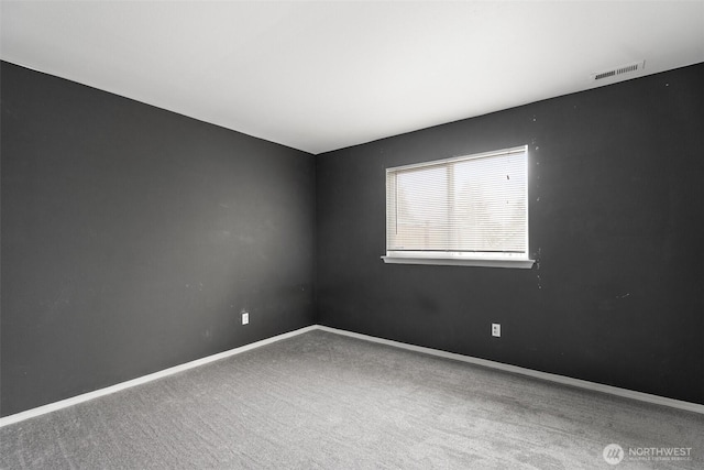 spare room featuring visible vents, baseboards, and carpet