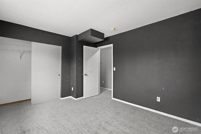 unfurnished bedroom featuring a closet, baseboards, and carpet