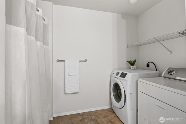 laundry area with laundry area, baseboards, and washer and clothes dryer