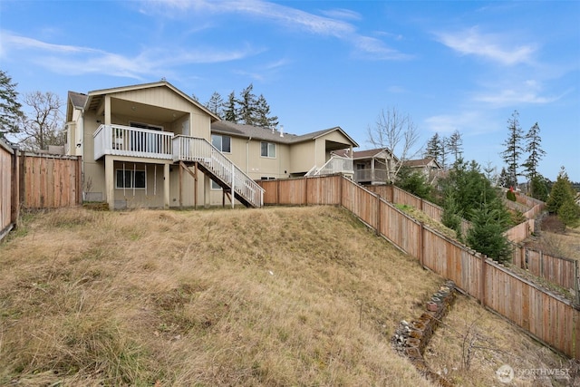 rear view of property featuring stairway and a fenced backyard