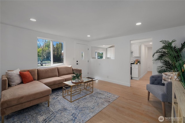 living room featuring recessed lighting, baseboards, and light wood finished floors