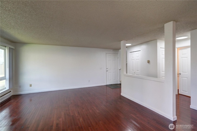 unfurnished room featuring dark wood-style flooring, a textured ceiling, and baseboards