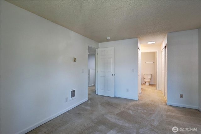 unfurnished bedroom with carpet floors, baseboards, visible vents, and a textured ceiling