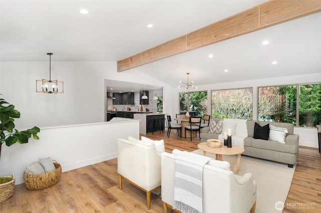 living room featuring vaulted ceiling with beams, light wood finished floors, recessed lighting, and an inviting chandelier