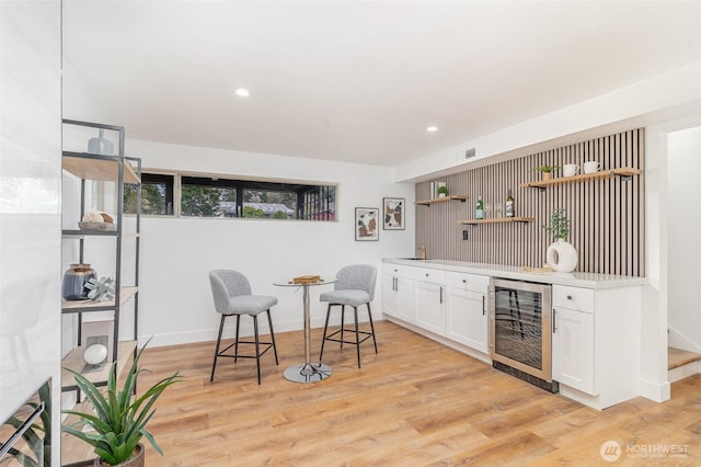 bar with recessed lighting, beverage cooler, visible vents, light wood-type flooring, and indoor wet bar