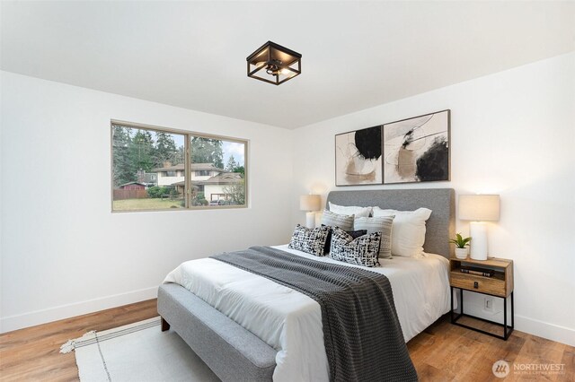 bedroom featuring wood finished floors and baseboards