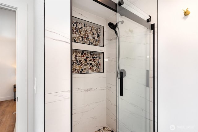 full bathroom featuring a stall shower and wood finished floors